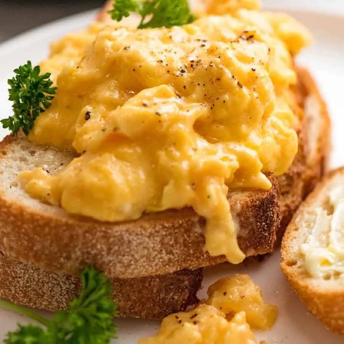 Creamy cheesy scrambled eggs with basil